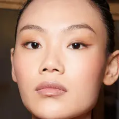 Nahaufnahme eines Gesichts mit makelloser Haut und dezentem Make-up.