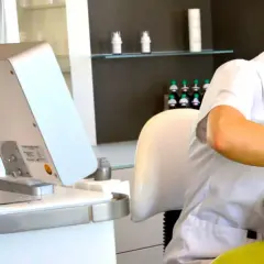 Kosmetikerin behandelt Kundin im Kosmetikstudio mit Gerät.