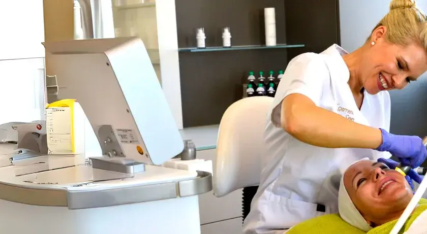 Kosmetikerin behandelt Kundin im Kosmetikstudio mit Gerät.