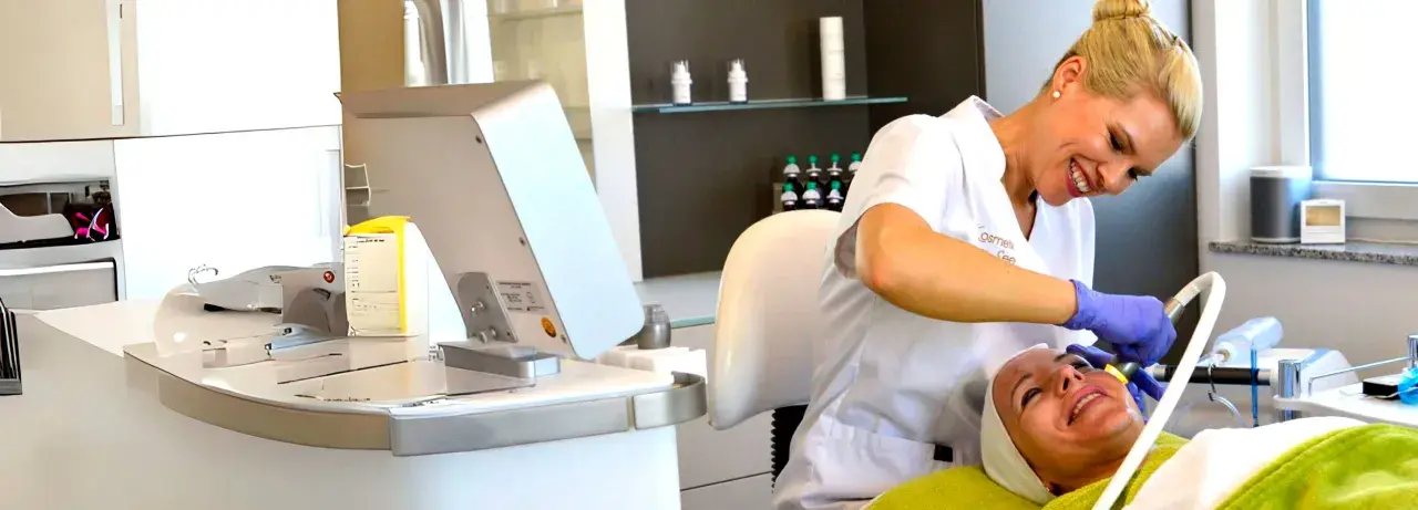Kosmetikerin behandelt Kundin im Kosmetikstudio mit Gerät.