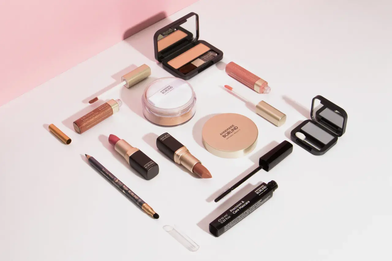 Annemarie Börlind Make-up: Lippenstifte, Lipgloss, Mascara, Lidschatten, Puder und Eyeliner auf weißem Hintergrund.
